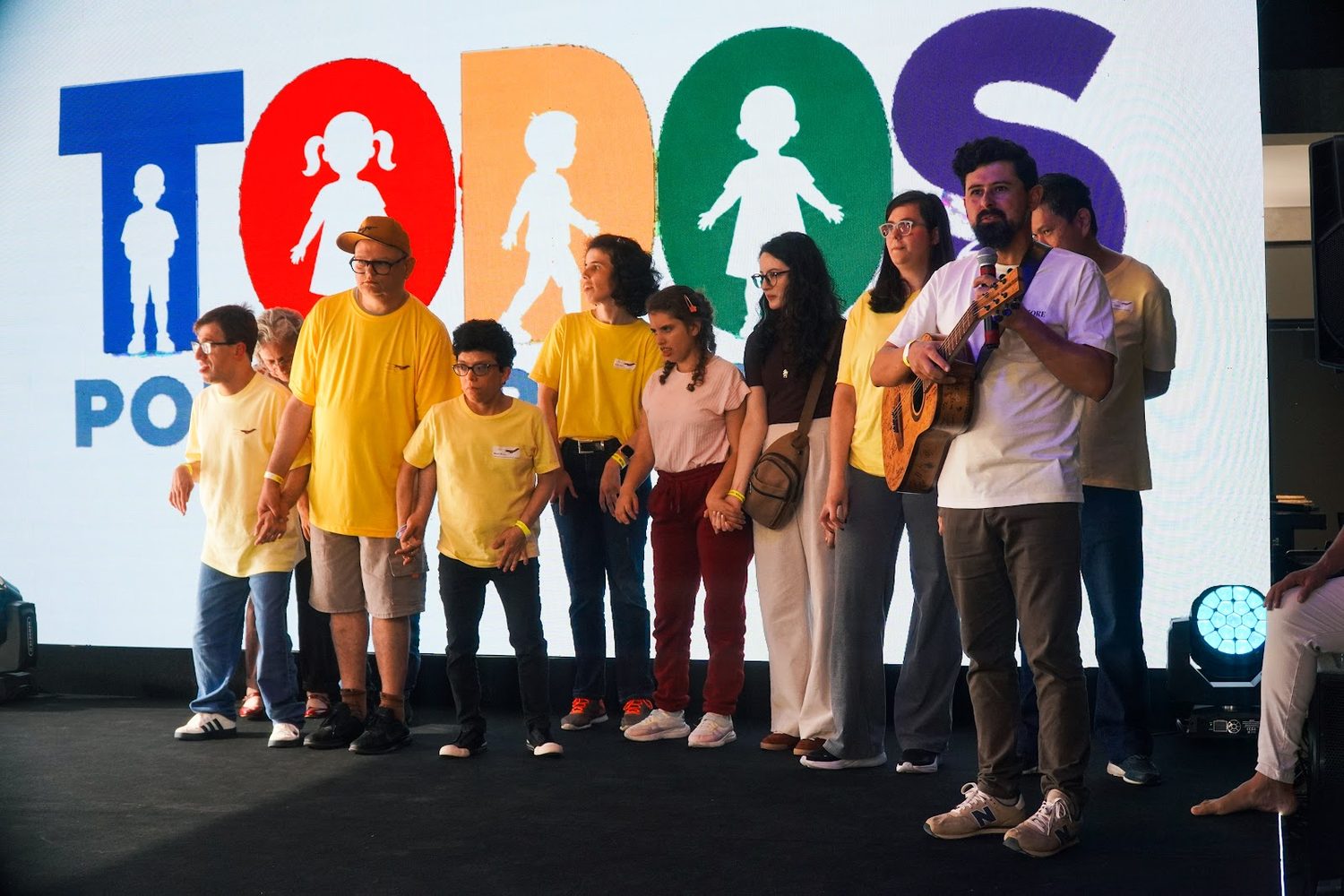 Grupo no palco diante do letreiro do evento